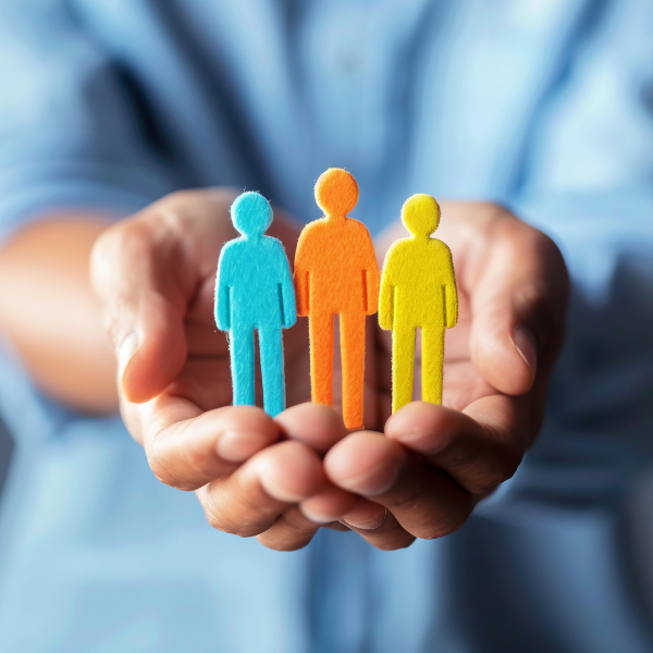 a pair of hands holding little human figurines