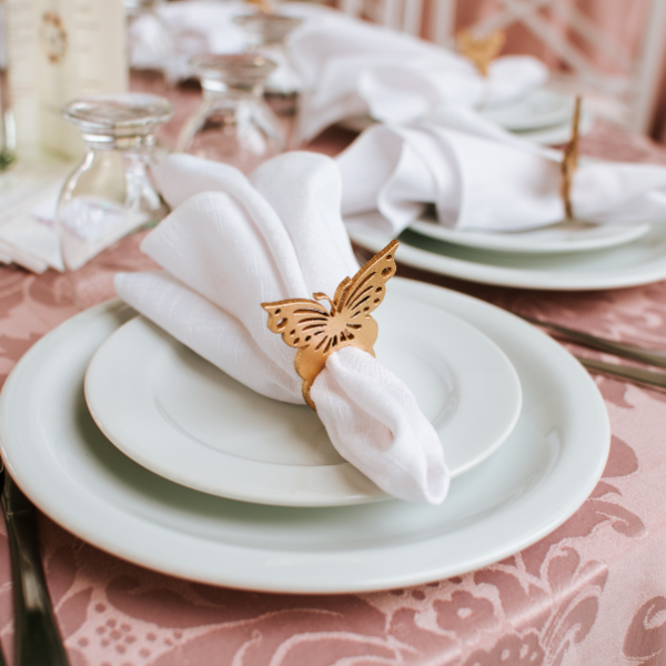a butterfly design napkin ring on a table napkin