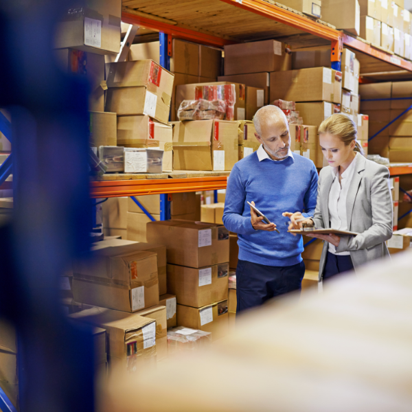 a man  and woman in a warehouse discussing