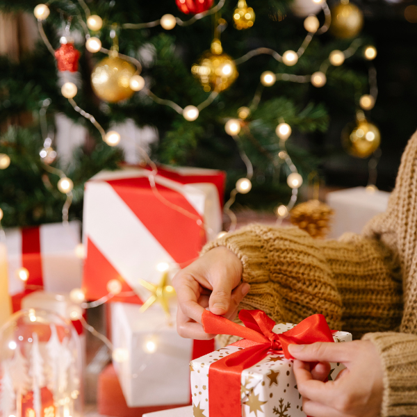 packing a box with Christmas tree in the background